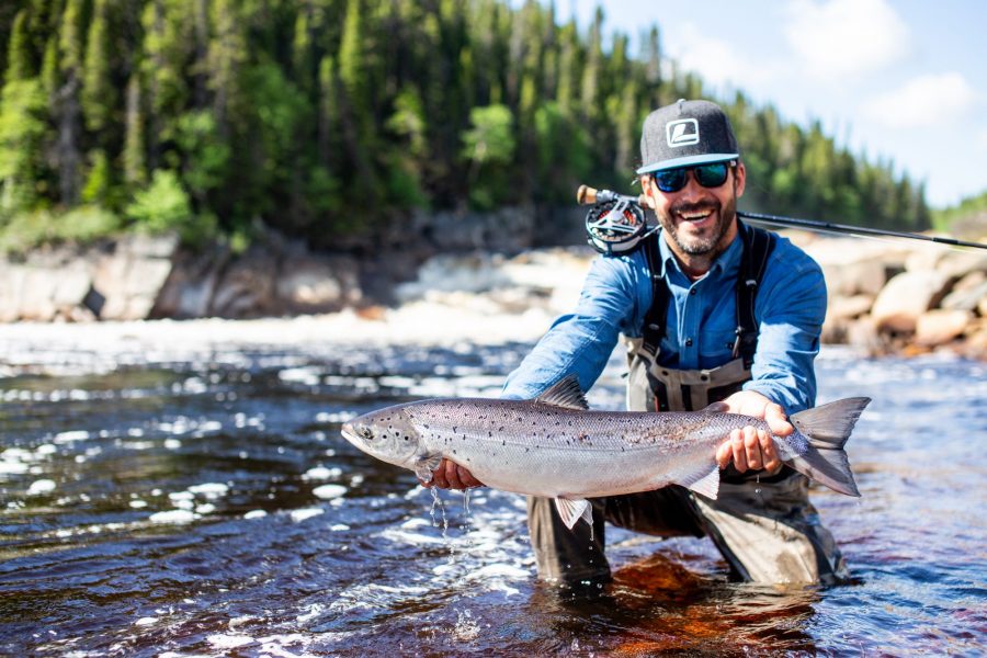 Angler holding his catch at St Lewis River, Canada